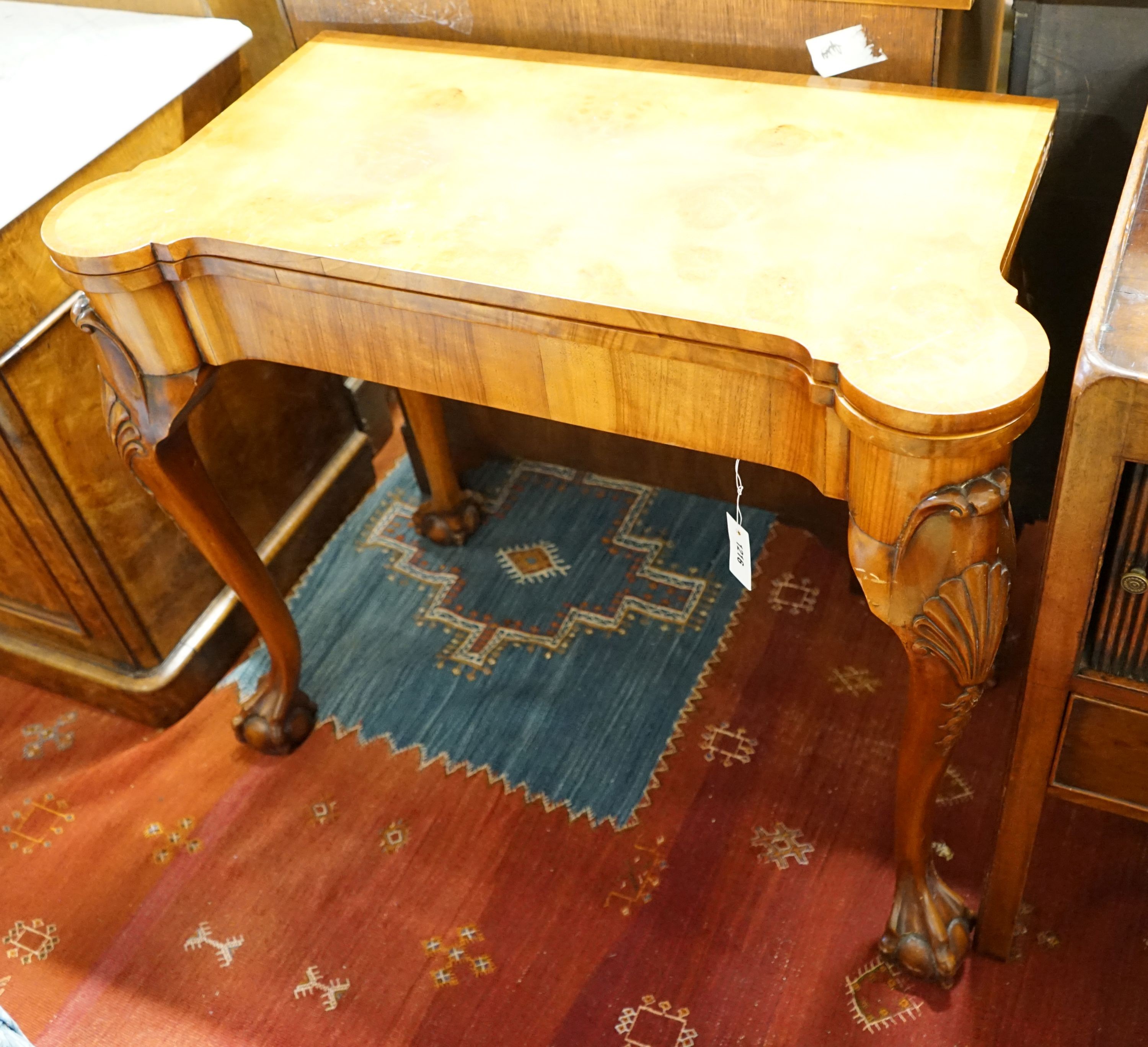 A Queen Anne revival burr walnut card table, with a red leather interior, length 86cm, depth 43cm, height 74cm